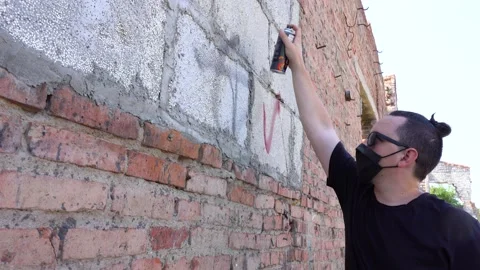 Man paints the wall with spray can Stock Footage 138923607