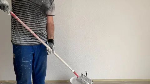 A man paints a wall in white Stock Footage 104760763
