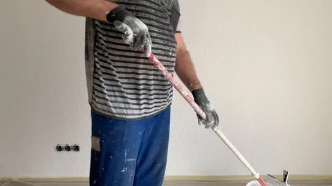 A man paints a wall in white Stock Footage 104760831