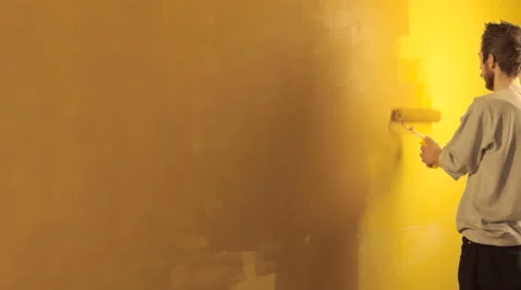 Man paints wall in yellow Video stock 62909176