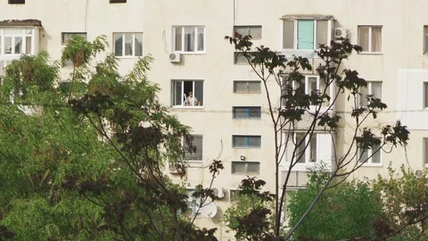 A man paints a window frame in a multi-storey residential building Stock Footage 107987986
