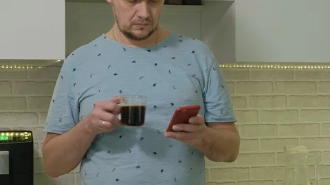 A man in pajamas drinking water in the kitchen. Morning Stock Footage 104043219