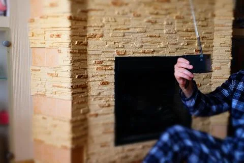Man in Pajamas Using Smartphone by Fireplace at Home Stock Photos