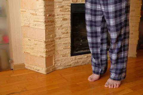 Man in Pajamas Using Smartphone by Fireplace at Home Stock Photos