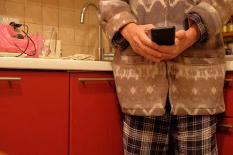 Man in Pajamas Using Smartphone by Fireplace at Home Stock Photos