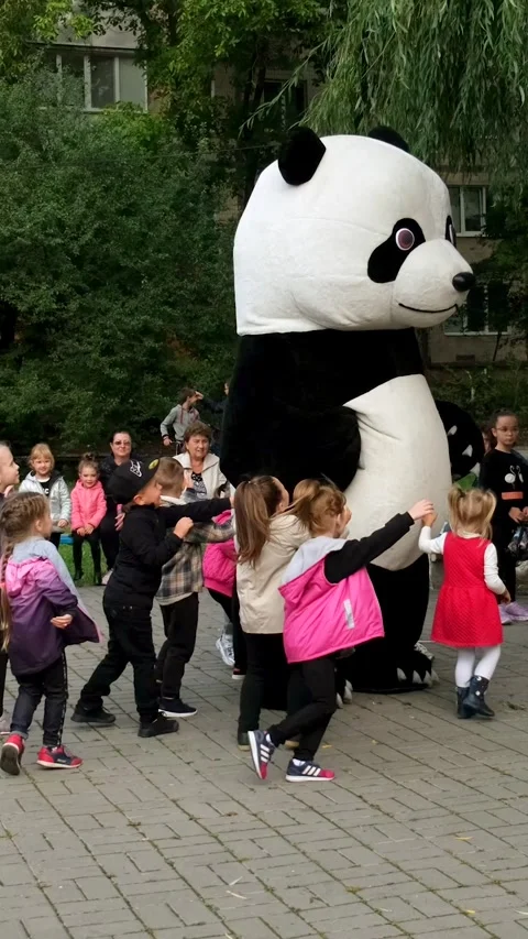 A man in a panda bear costume dances and entertains children Stock Footage 306149464