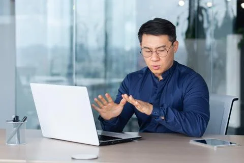 Man panic attack at work, office worker worried breathing hard, asian man Foto stock