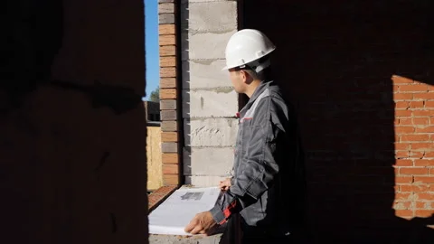 Man with paper draft in building under construction Stock Footage 97977982