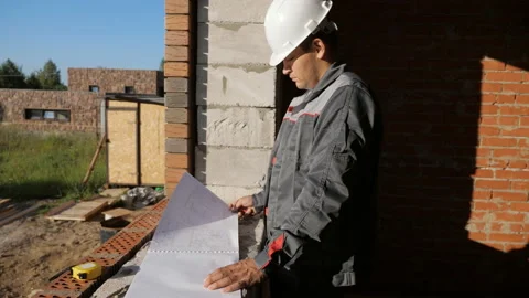 Man with paper draft in building under construction Stock Footage 98085439