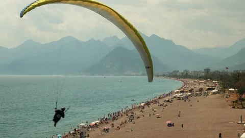 Man with parachute flying over sandy beach. Paragliding. Summer recreation Stock-Footage 188621879