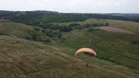 A man with a parachute in a hilly landscape Stock Footage 165165765