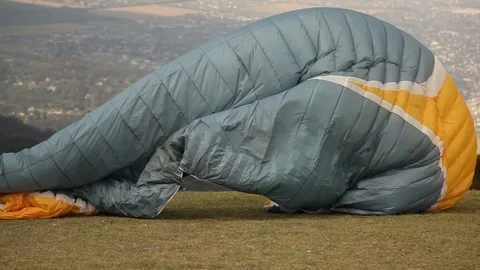  man in paraglider runs through a green meadow and flies Stock Footage 123799875