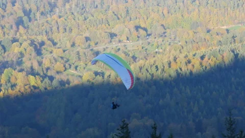 The man is paragliding doing. It flies on a special parachute high above the Stock Footage 222947526
