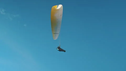 Man paragliding under cloudy sky at sunset. Extreme Sport Concept Stock Footage 263857804