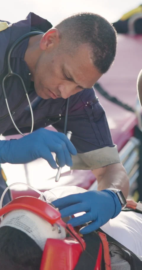 Man, paramedic and flashlight to check patient, critical condition and first aid 스톡 동영상 252641827