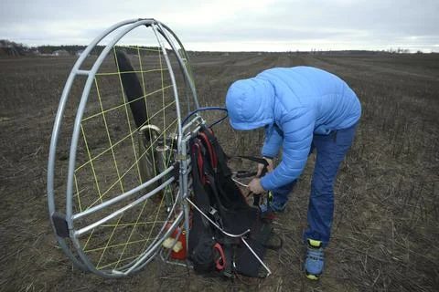 Man paramotorist preparing the paramotor for flight Stock Photos