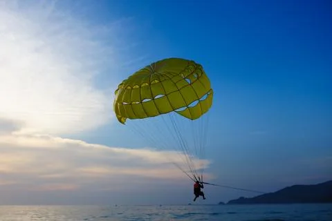 Man parasailing at sunset Stock Photos