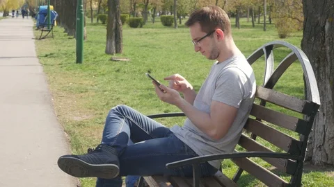 Man in the park uses a smartphone Stock Footage 88863324