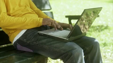 Man in a park using a laptop Stock Footage 11340855