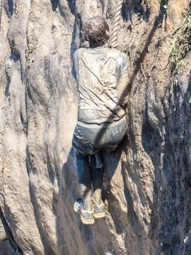 Man pass the obstacle course. Mud race runners. Teamwork. 写真素材