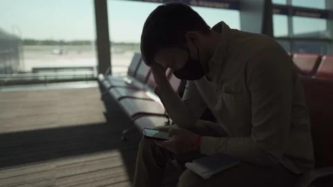 Man passenger with backpack in protective mask waiting for boarding a plane Stockbeeldmateriaal 154752027