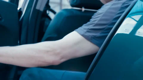 A man passenger opens a blue car door, sits in the back seat and closes the door Stock Footage 138254985