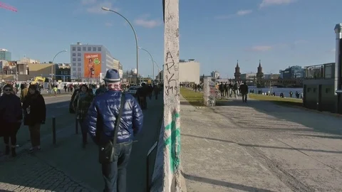 Man passes a gap in the Berlin Wall, going from former west to former east Stock Footage 76099029