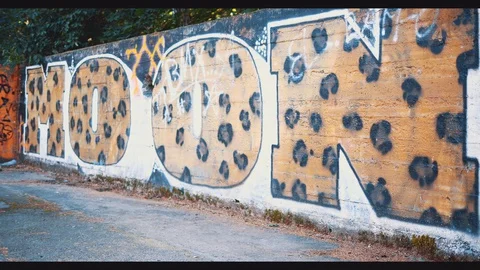 Man is passing by graffiti background with BMX. Copy space. 4K. Stock Footage 128308651