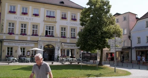 Man passing one of the hotels at inner city of Altötting, Germany 4K Stock Footage 113913175