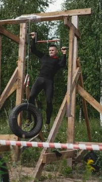 Man passing through hurdles during obstacle course in boot camp Stock Photos