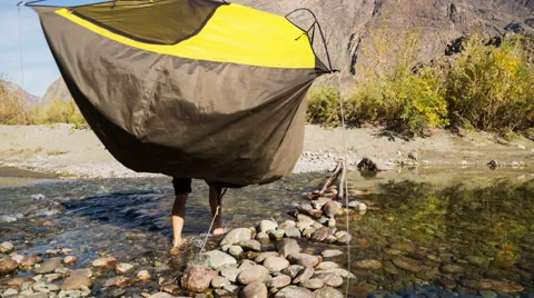 Man passing through the mountain river Stock Footage 48894060