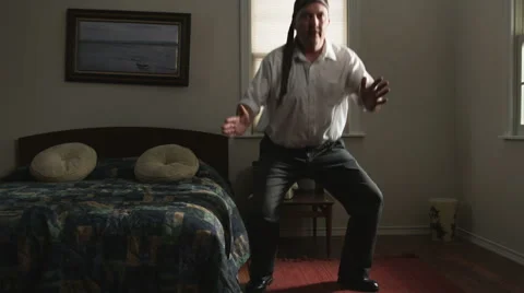 Man passing time by wearing his tie as a headband and acting like a ninja Stock Footage 43113363