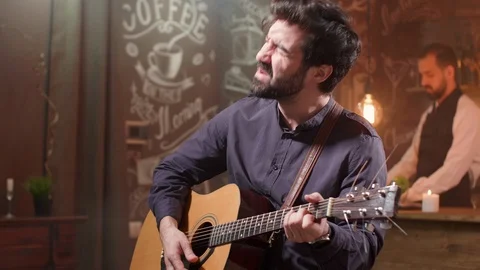 Man passionately performing a composition on an acoustic guitar Stock Footage 107186793