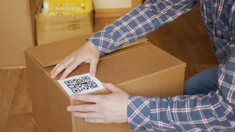 A man pastes a  QR code on a box. Delivery service. Online shop. Bar code. Stock Footage 88578933