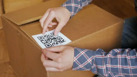 A man pastes a  QR code on a box. Delivery service. Online shop. Bar code. Stock Footage 88588410