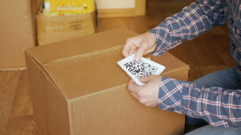 A man pastes a  QR code on a box. Delivery service. Online shop. Bar code. Stock Footage 105848101