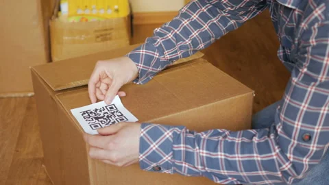 A man pastes a  QR code on a box. Delivery service. Online shop. Bar code. Stock Footage 115426370
