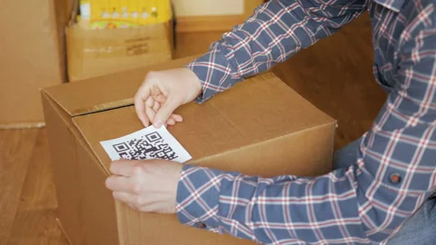 A man pastes a  QR code on a box. Delivery service. Online shop. Bar code. Stock Footage 125386128