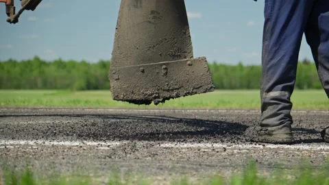 Man patching road. Road surface repair. Pothole asphalt road repairs Stock Footage 247820767
