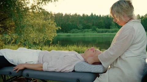 Man patient lying on massage table during procedure at nature. Massage spa Stock Footage 317332083