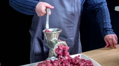 A man pauses for a second and then continues griding meat Stock Footage 59739578