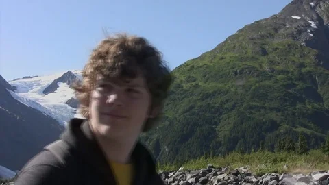 Man pauses while hiking to view iceberg Stock Footage 78940393