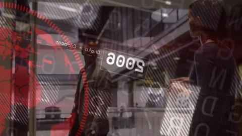 Man pausing at elevator, woman tapping tablet and showing red HUD numbers for 库存影片 332577743