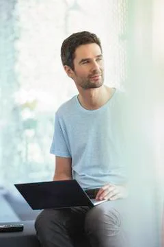 Man pausing for reflection while using laptop computer Stock Photos