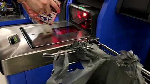 Man paying chocolate at self-check out counter inside Walmart store 스톡 동영상 65404549