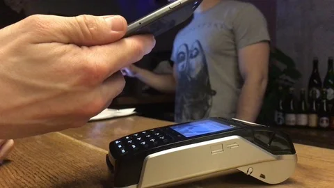Man paying with NFC technology on mobile phone, restaurant, cafe, bar Stock Footage 107589129