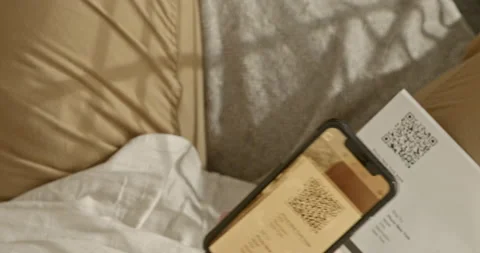 Man pays invoice with qr code via internet banking. He is sitting on the couc 스톡 동영상 201203651