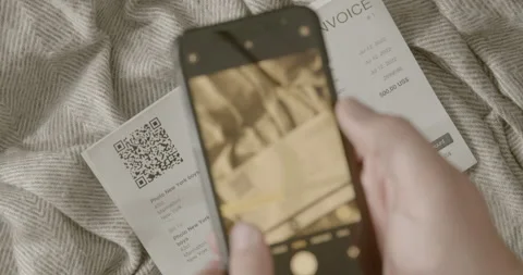 Man pays invoice with qr code via internet banking. He is sitting on the couc 스톡 동영상 201204842