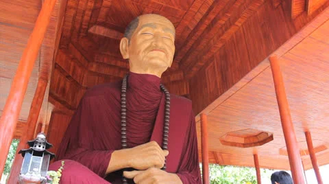 Man Pays Respect To Oversized Buddhist Monk Statue Stock Footage