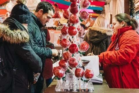 Man pays for sweets at a stall in Winter Wonderland Christmas Fair in London, Stock Photos